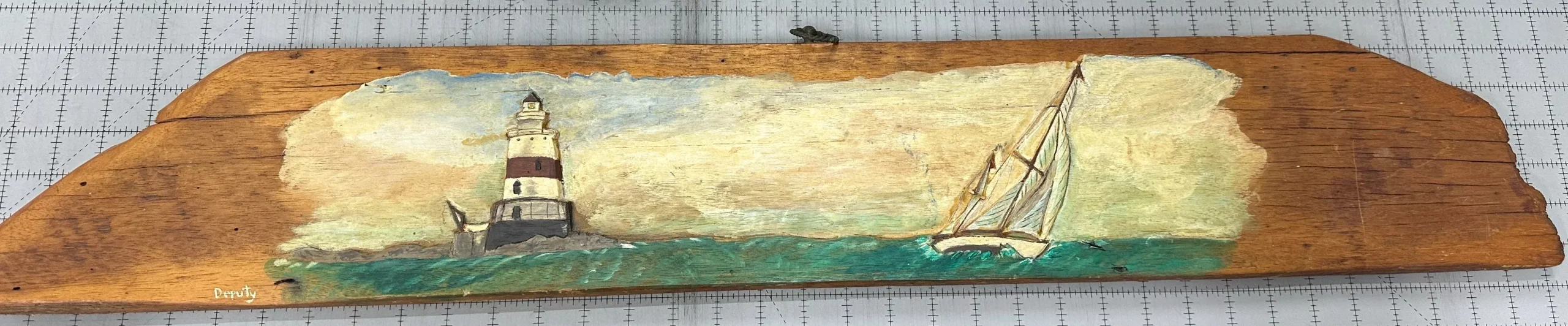Vintage driftwood art featuring sailboat and lighthouse